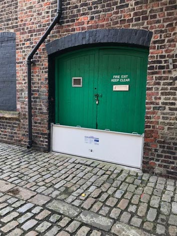 A business door with a flood gate set up in front