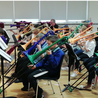 A group of kids playing with trombones