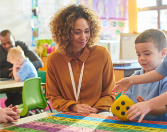 Lady working in childcare setting with a little boy.