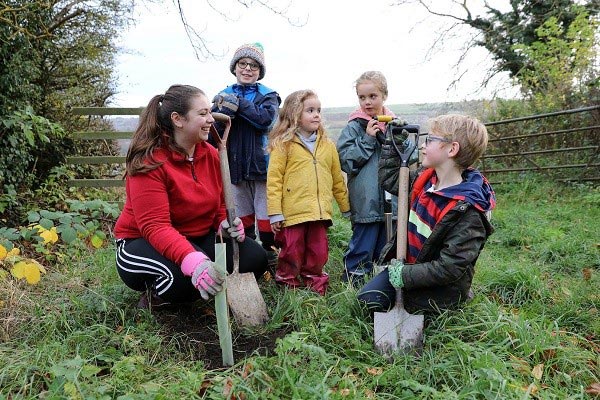 Children planting trees as part of the Queen's Green Canopy
