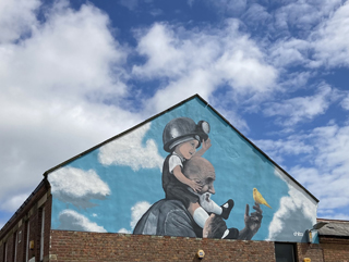 Young miner and father's shoulder painted on side of Ashington building 