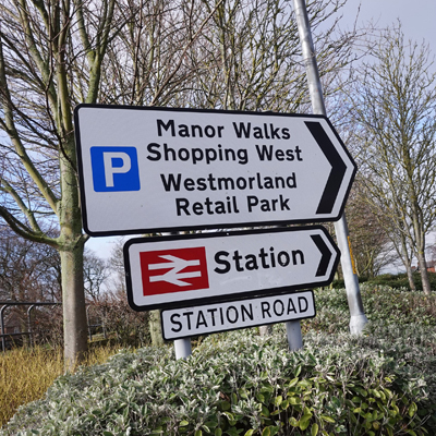 Road sign directing people to Manor Walks Shopping Centre 