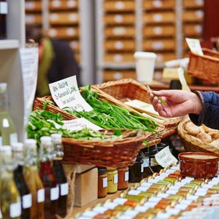A person at a farmers market looking at the items on a table
