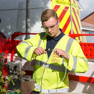 A worker investigating a broadband cable