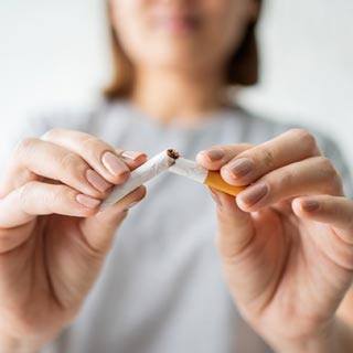 A person breaking a cigarette in half