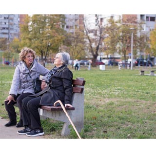 Two friends sitting on a park bench together