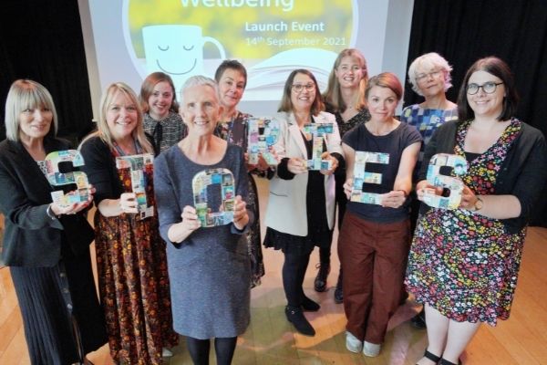 Reading Facilitators standing with Ann Cleeves.  They are holding up letters that spell out the word Stories.