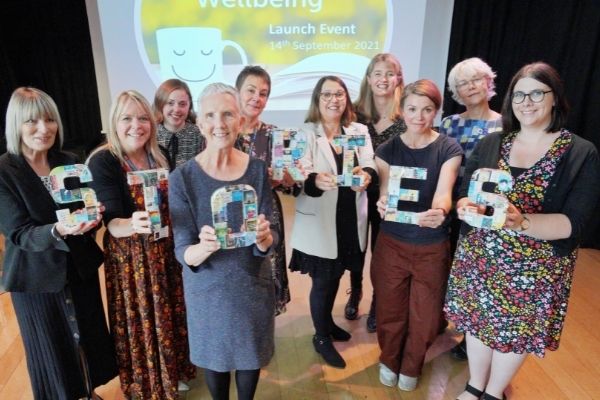 Reading Facilitators standing with Ann Cleeves.  They are holding up letters that spell out the word Stories.