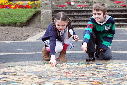Two children looking at a mosaic