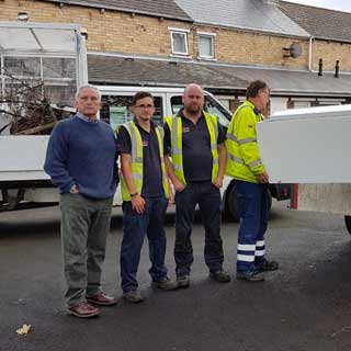 A fridge being loaded onto a wagon