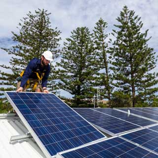 Man installing solar panels on a roof