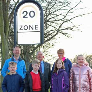 Children underneath a 20mph sign