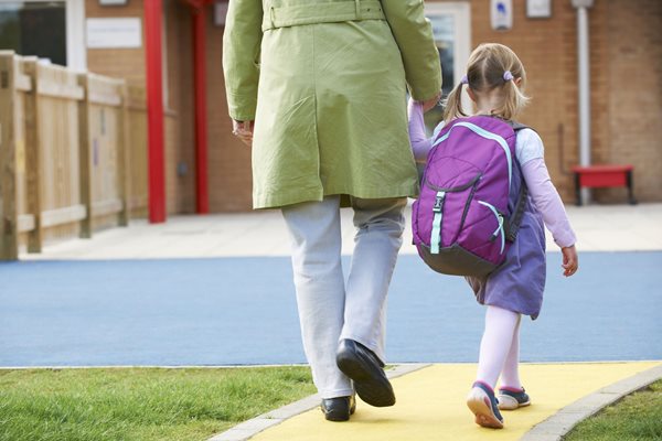 parent and young child walking into school