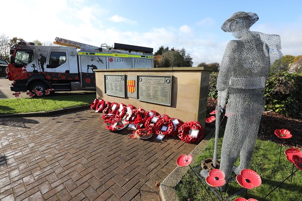 War memorial with poppy wreaths laid in front of it