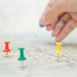 Image of a map with coloured pins in it.