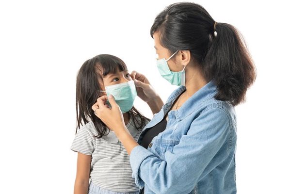 Mother putting mask on child