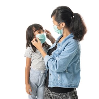 Mother putting mask on child