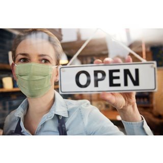 Photo of woman in mask turning Open sign