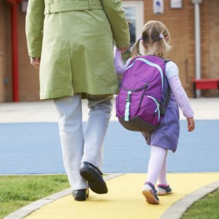 parent and young child walking into school