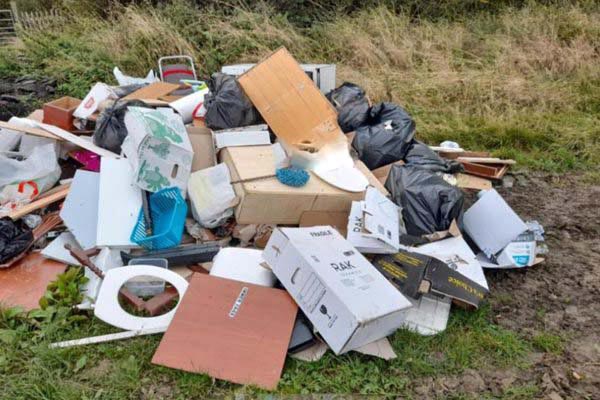 A lot of fly tipping dumped in a field. 