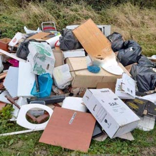 A lot of fly tipping dumped in a field. 