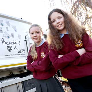 Two year seven pupils from Corbridge Middle School next to a bin wagon 