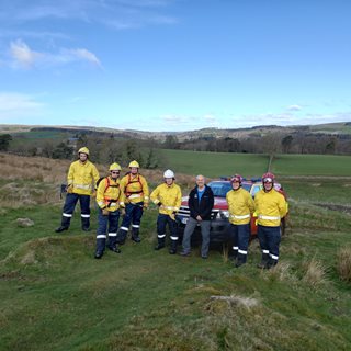 Wildfire crew with fire support vehicle out in a field