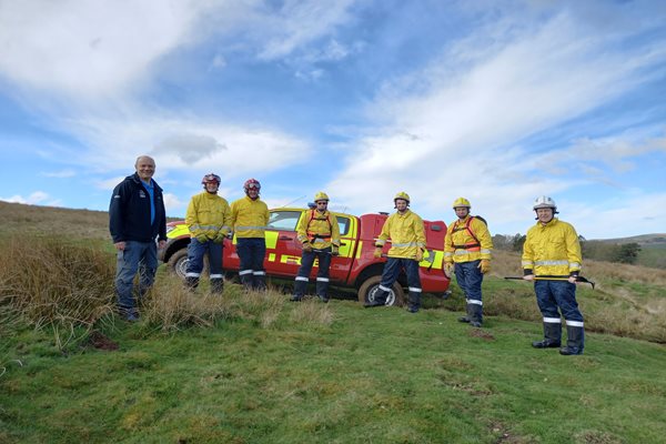 Wildfire crew with fire support vehicle out in a field