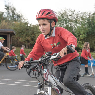 A child cycling. Pupils at Allendale Primary School celebrating being shortlisted for a national award for their commitment to choosing cleaner and healthier ways to travel to school.