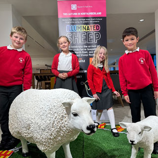 Pupils from Morpeth First School visiting the illuminated sheep at County Hall