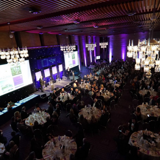 Photo of the North East England Tourism Awards. Round Tables with groups of people sitting at them looking towards a raised stage where winners of awards are being announced.