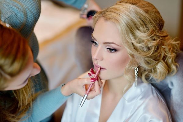 Bride looking off camera getting makeup professionally applied