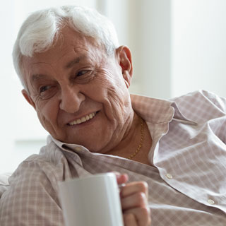 An older man having a cup of tea. Residents are encouraged to support Silver Sunday on October 2nd