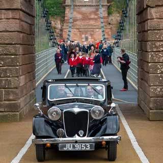 The first car and local children over the newly reopened Union Chain Bridge