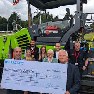 People holding a big cheque to mark the council's contractors giving benefits to the community