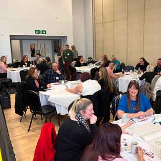 Groups of people discussing employment barriers at Newbiggin