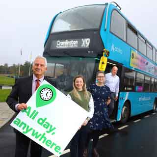 People on a bus holding up a sign which says All day anywhere