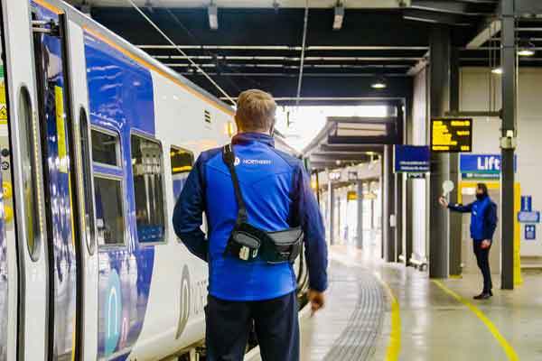 A Northern conductor standing by a train