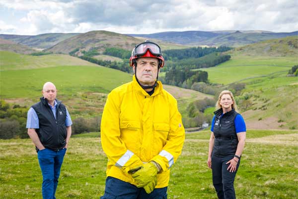 Council staff, fire officers and countryside rangers on a hillside.