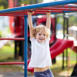 A child playing on monkey bars in a playground