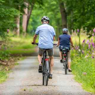 Two people biking down a country lane