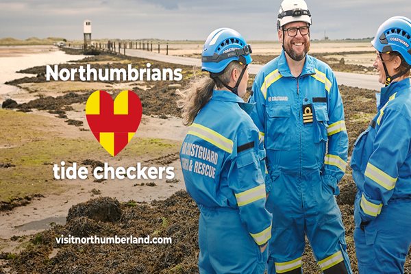 Three coastguard members on a beach 