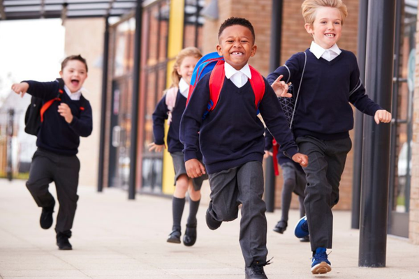Children running happily in school uniform