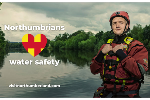 A firefighter by a river promoting water safety