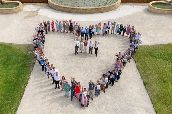 An aerial view of people forming a heart shape