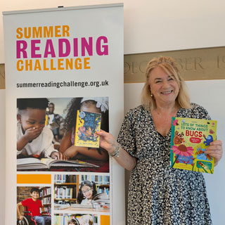 Councillor Wendy Pattison in front of a summer reading challenge sign