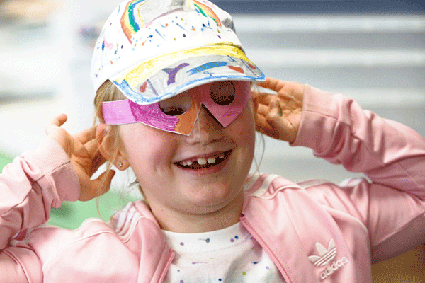 Young girl with blond hair taking part in an activity group