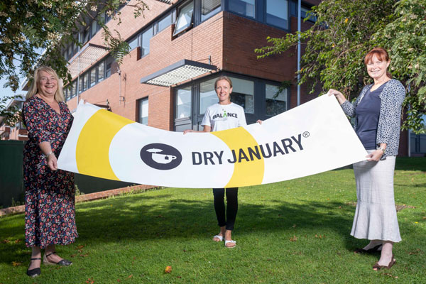 Colleagues holding a Dry January banner