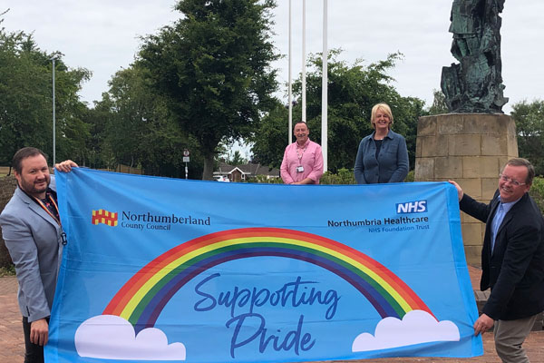 Cabinet members holding a Pride banner