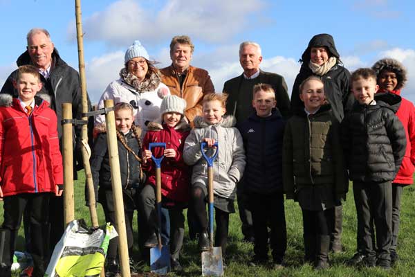 Councillors, staff and schoolchildren planting a tree